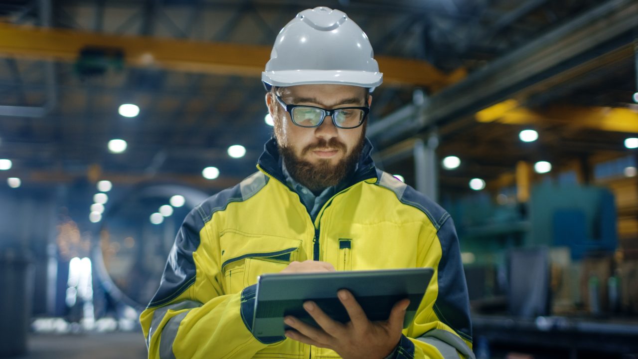 Worker using a tablet to complete a Fire Risk Assessment