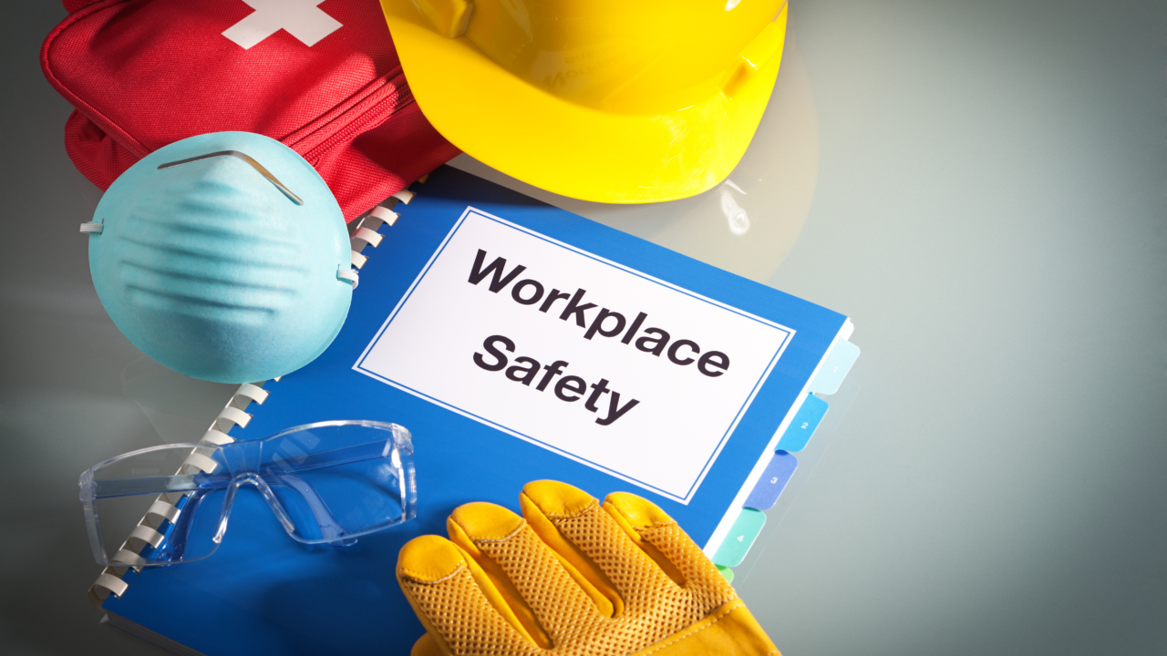 Workplace Safety handbook with PPE surrounding