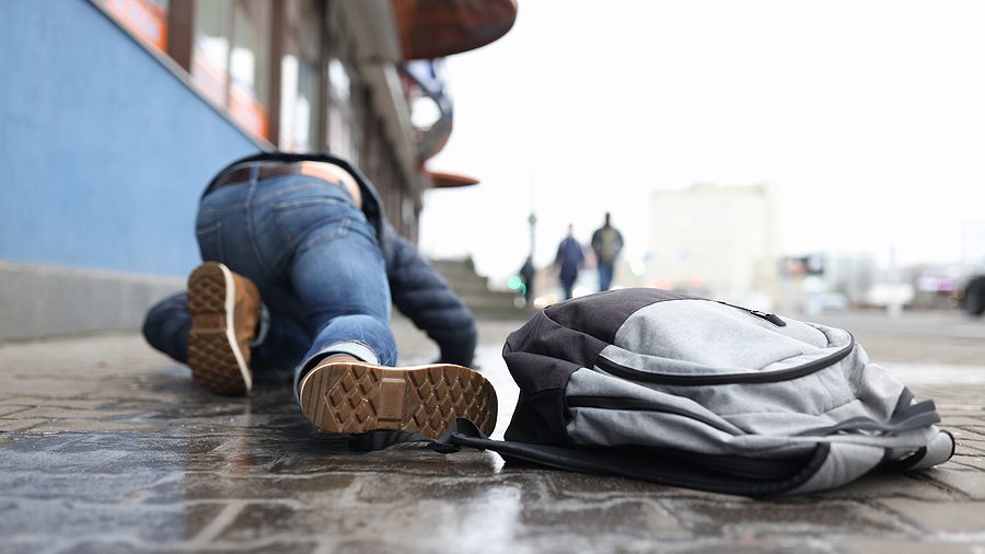 An example of poor winter safety precautions where a man has slipped on an icy pathway.