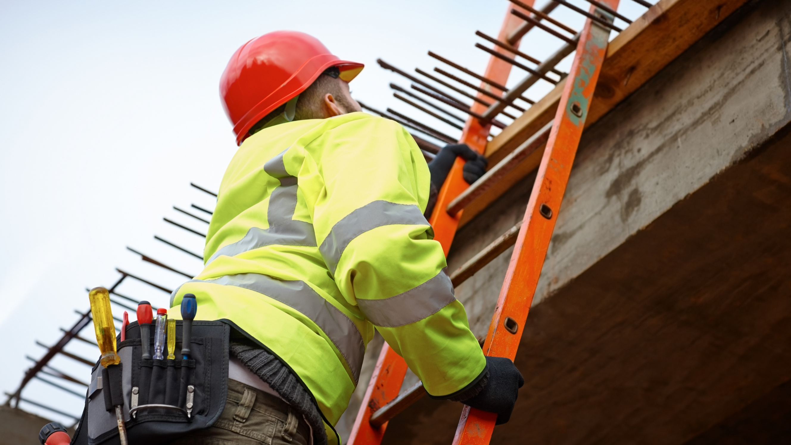 Workman Climbing a ladder whilst working alone outside.